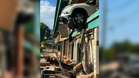 SUV crashes through Whole Foods parking garage wall, hangs partially over edge