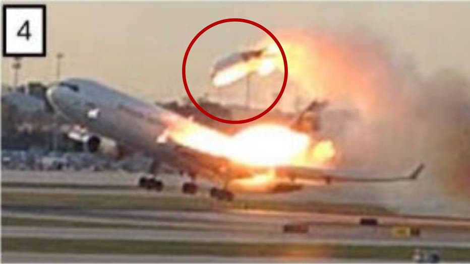 A flaming airplane taking off, with one of the engines seen thrown above the plane covered in flames.