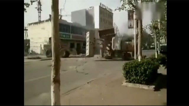 Angry Chinese construction workers duel with bulldozers