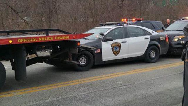 Stolen tow truck drags cop car with officer inside