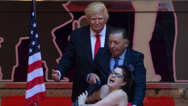 Topless protester attacks Trump statue