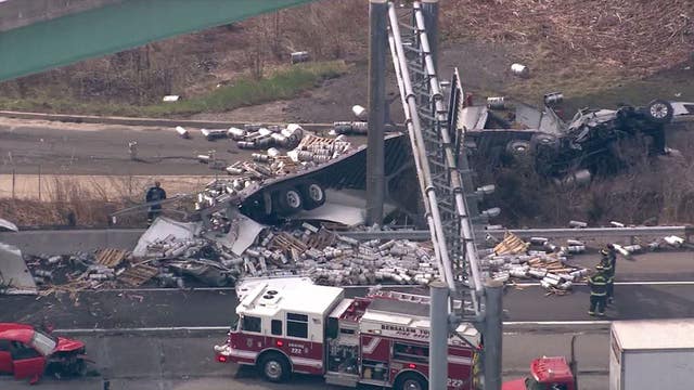 Tractor-trailer rolls off overpass onto I-95 spilling empty beer kegs