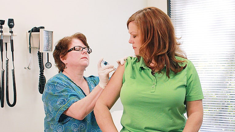 A health care professional gives a flu shot to a patient.
