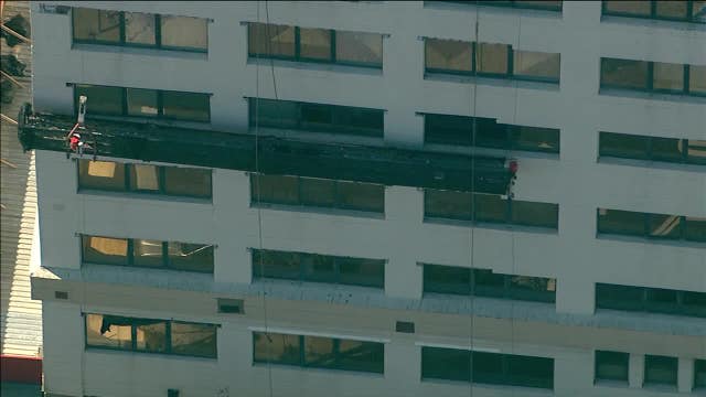Scaffolding collapse leaves worker dangling in mid-air