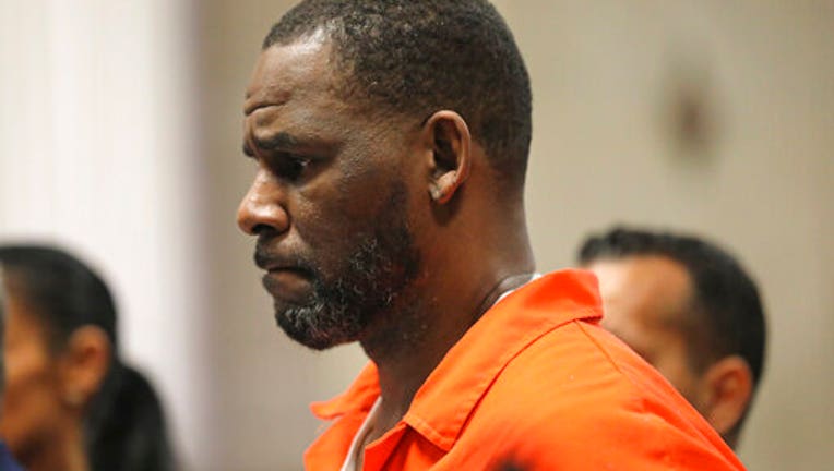 R. Kelly, wearing an orange jumpsuit, appears in a courtroom