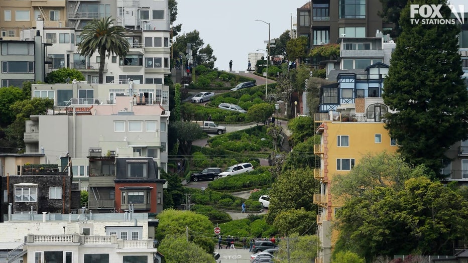 FILE - In this April 15, 2019, file photo, cars wind their way down Lombard Street in San Francisco. Thousands of tourists could soon be forced to make reservations and pay to drive the famed crooked Lombard Street in San Francisco. California lawmakers approved a bill Thursday, Sept. 5, 2019, granting San Francisco the power to establish a toll and reservation system for Lombard Street. The bill still needs Gov. Gavin Newsom's signature. The San Francisco County Transportation Authority has suggested $5 per car weekdays and $10 weekends and holidays. (AP Photo/Eric Risberg, File)