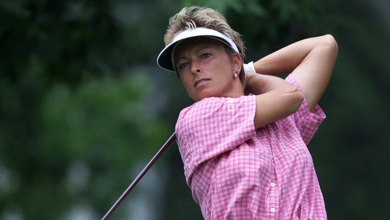 Golfer Dottie Pepper swings a club