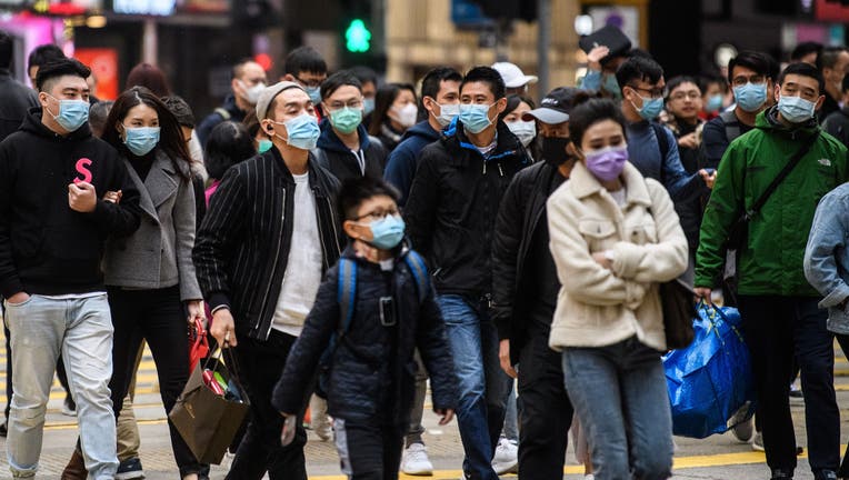 Pedestrians wearing face masks cross a road during a Lunar New Year of the Rat public holiday in Hong Kong.