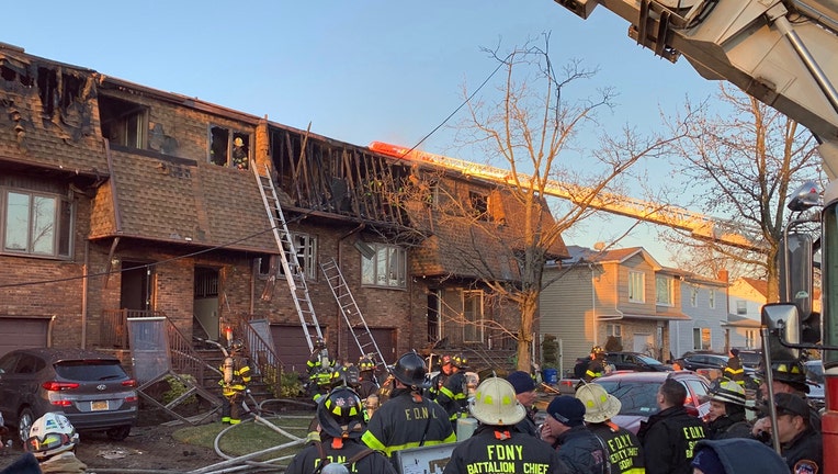 Firefighters outside a row of homes burned in a fire