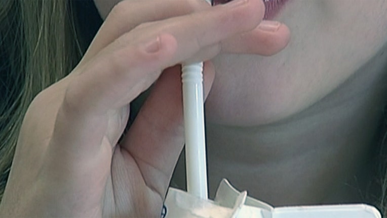 Child drinking milk through a straw