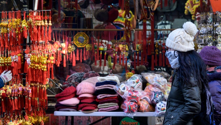 People wear masks as they walk through New York's Chinatown in New York City on February 14, 2020. (Photo by Johannes EISELE / AFP) (Photo by JOHANNES EISELE/AFP via Getty Images)