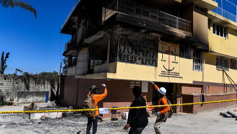 Firefighters speak to a local judge (C) as they point at the Orphanage of the Church of Bible Understanding where a fire broke out the previous night in the Kenscoff area outside of Port-au-Prince February 14, 2020. - The fire killed 15 children. (Photo by CHANDAN KHANNA / AFP) (Photo by CHANDAN KHANNA/AFP via Getty Images)