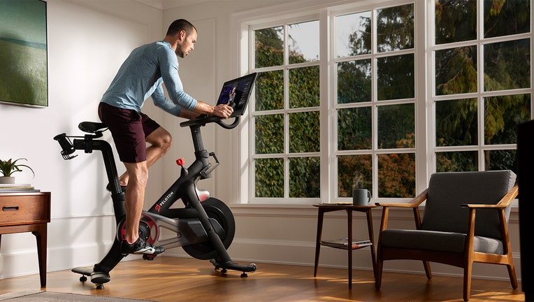 A man rides a Peloton exercise bike