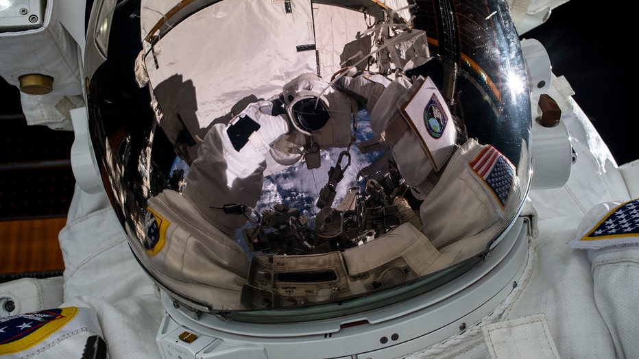 Astronaut's camera reflected in helmet of space suit
