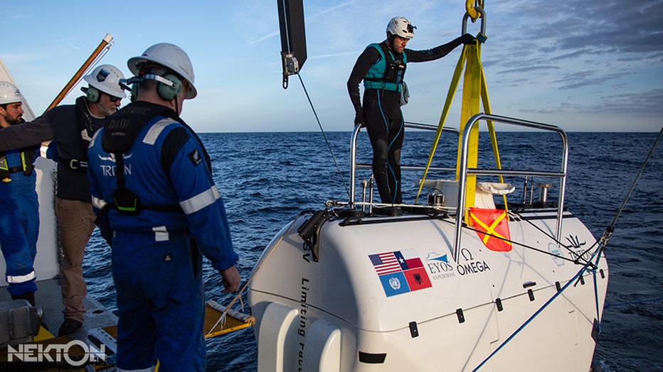 Small submarine being lowered into the sea