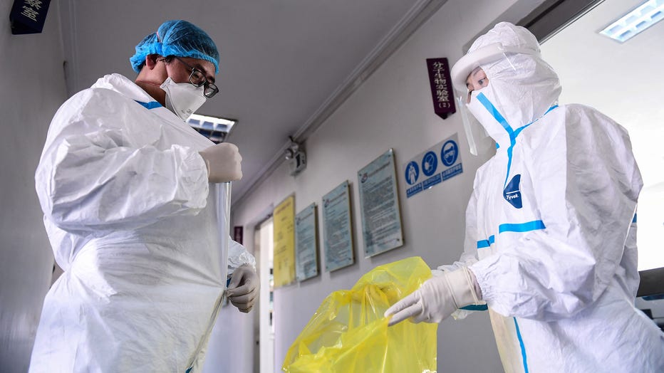A laboratory technician removes his protective suit after leaving a laboratory in Shenyang in China's northeastern Liaoning province on Feb. 12, 2020. (Photo by STR/AFP via Getty Images)