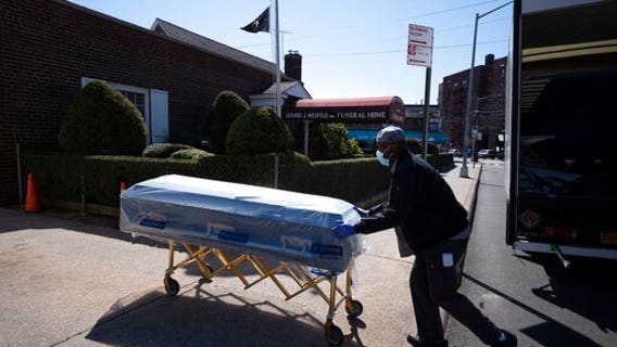 Closed caskets, empty chairs at funeral home in Queens
