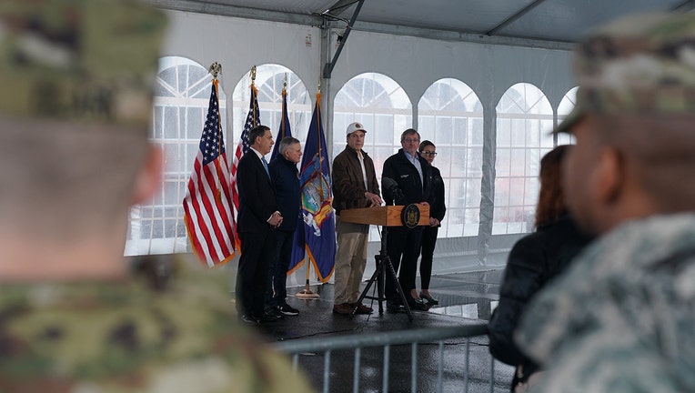 Cuomo and others making an announcement in a tent