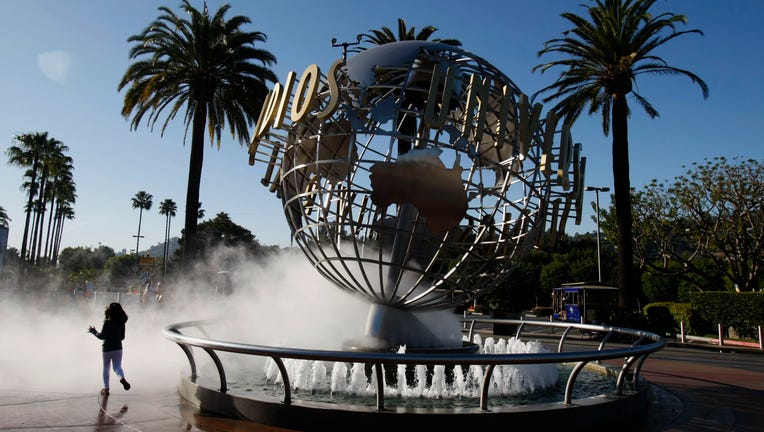 On a beautiful day in Southern California, Pammy Hamm, 6, runs through the spray at the entrance of