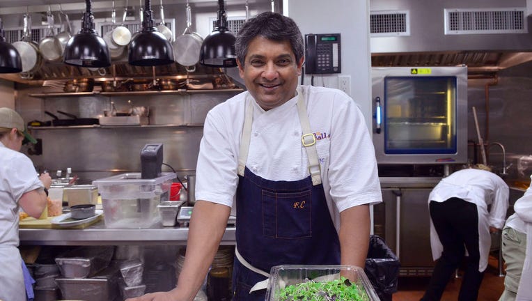 Chef Floyd Cardoz smiling in a kitchen