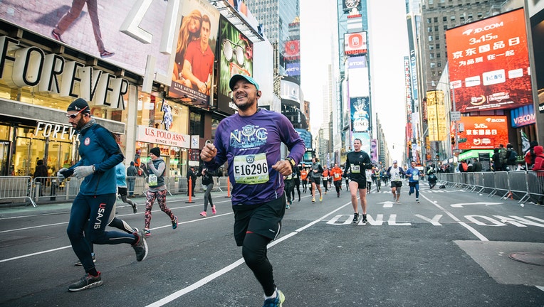 A smilling runner runs through Times Square 