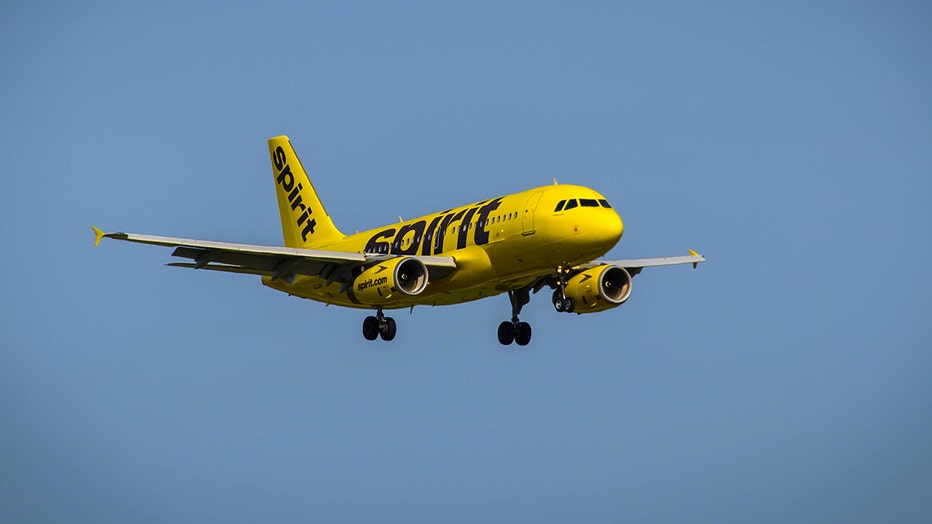 A Spirit Airlines Airbus A319 flying against the backdrop of a clear blue sky