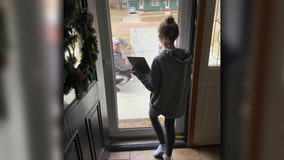 Math teacher brings over whiteboard to help student through glass door