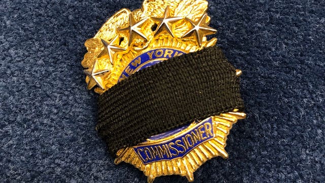 NYPD officers wearing black bands on badges to honor COVID-19 dead