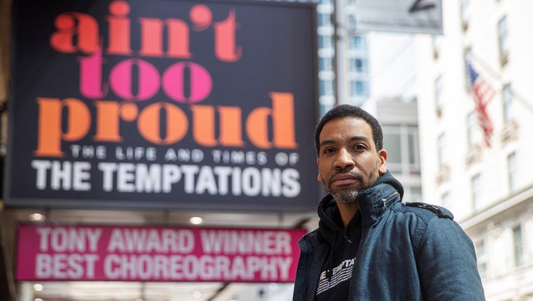 E. Clayton Cornelious with the marquis of a Broadway show behind him