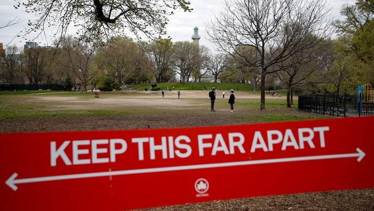 Red and white sign with Fort Greene Park in background