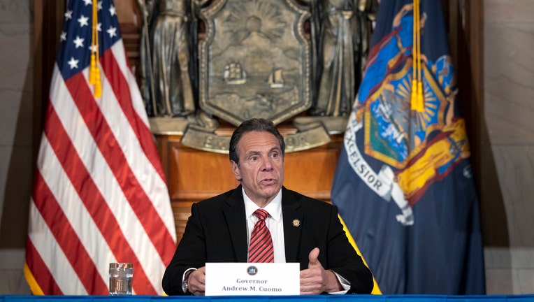 Andrew Cuomo speaks from behind a table