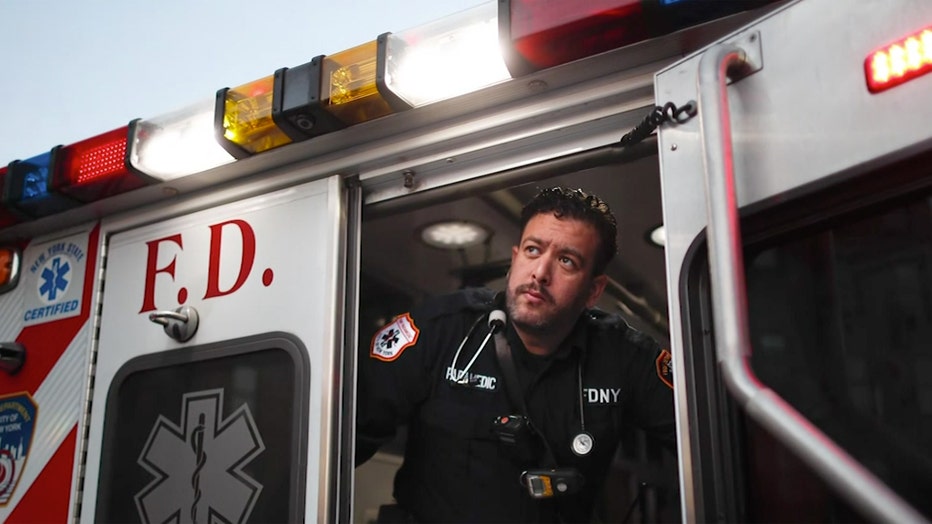 Paramedic poses in door to ambulance