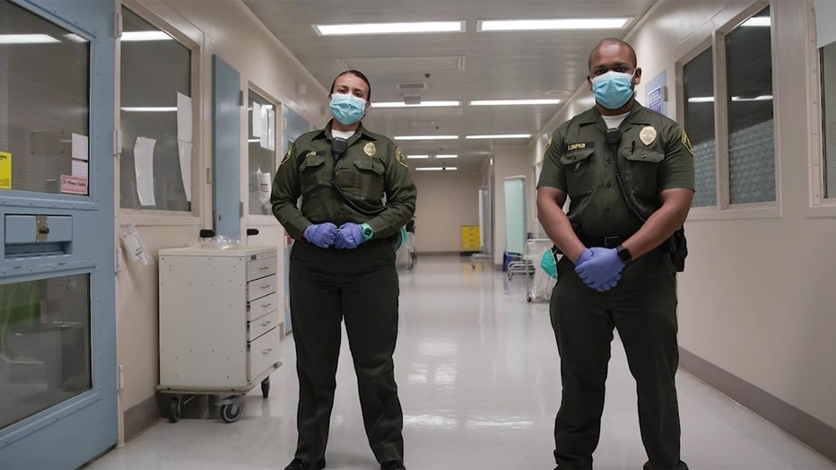 Uniformed jail guards wearing masks and gloves