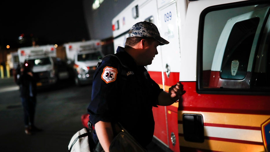 Paramedic Travis Kessel holds the door of an FDNY ambulance