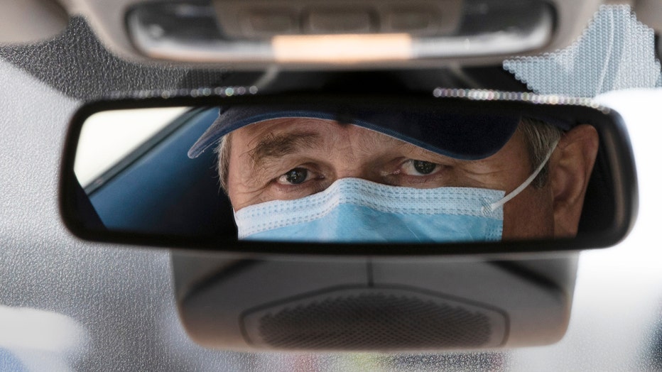 Taxi driver Nicolae Hent's face seen in rearview mirror