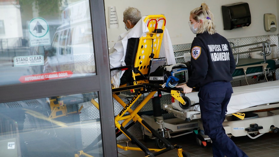 Paramedic pushes a patient on a wheeled stretcher