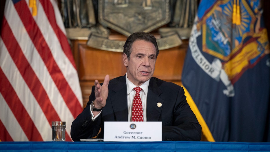 Cuomo at a table with flags behind him