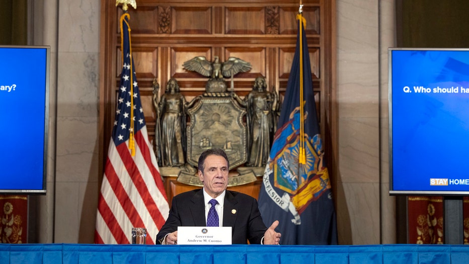 Gov. Andrew Cuomo speaks from behind a desk in Albany with U.S. flag and New York flag behind him