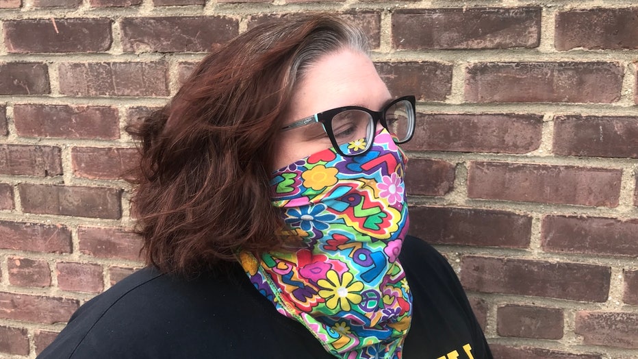 A woman wears a colorful bandana