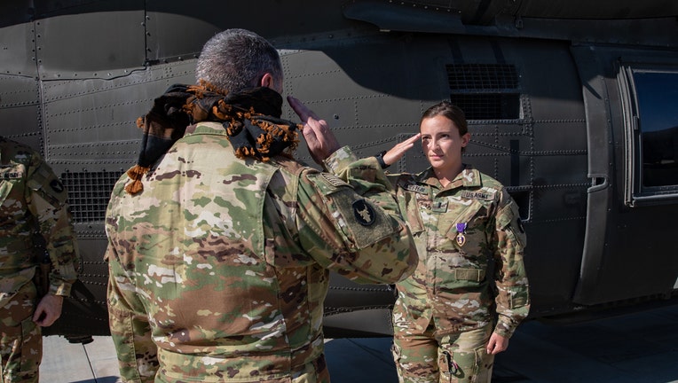 A soldier wearing a Purple Heart medal salutes a superior officer