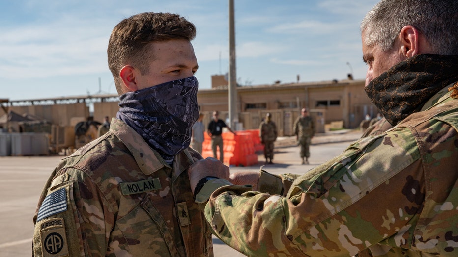 An officer pins a medal on a soldier