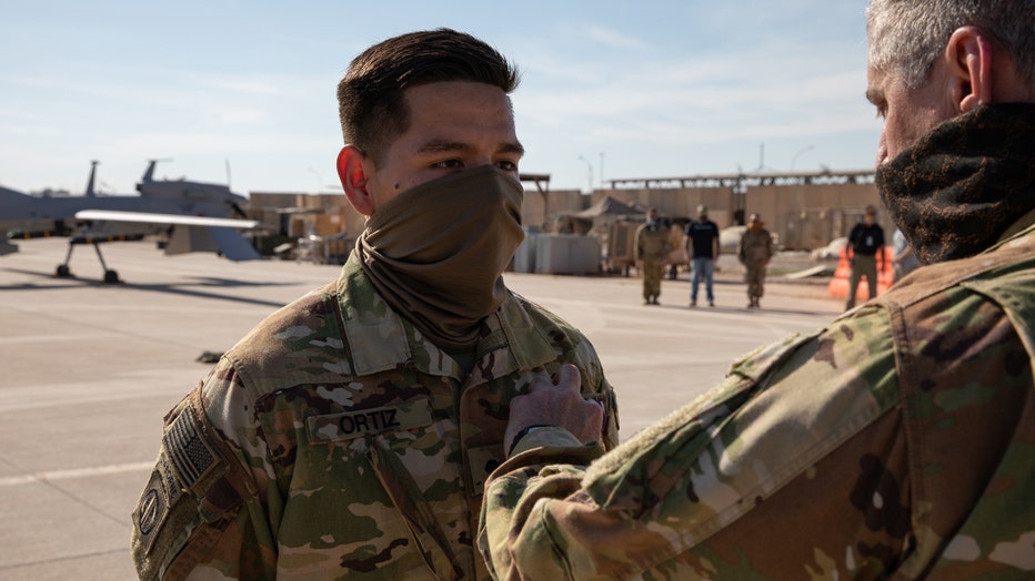 An officer pins a medal on a soldier