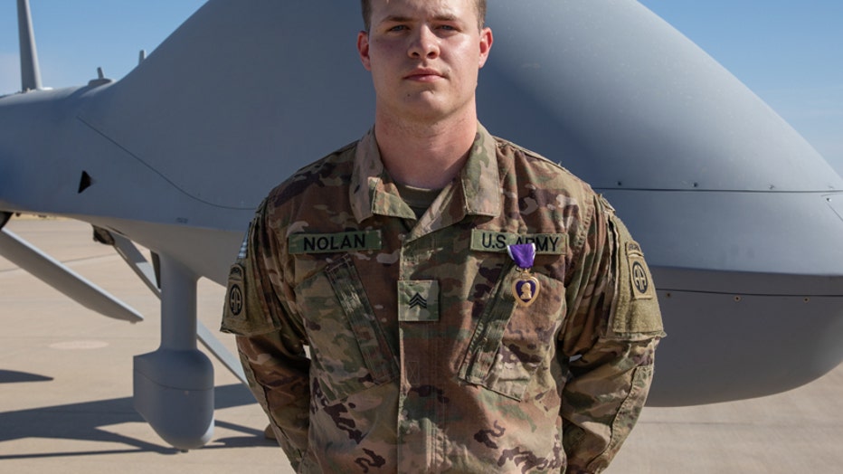 A soldier wearing a Purple Heart medal poses for a photo