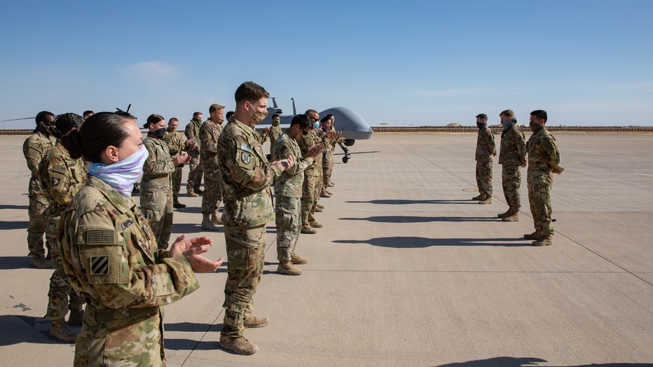 Soldiers clap for fellow service members on a base