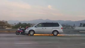 Sparks fly as minivan drags motorcycle along 91 Freeway in Corona