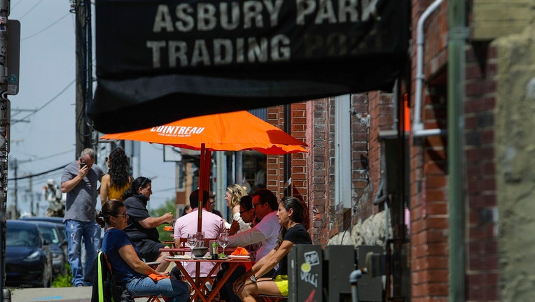 Patrons sitting at tables on the sidewalk outside a restaurant