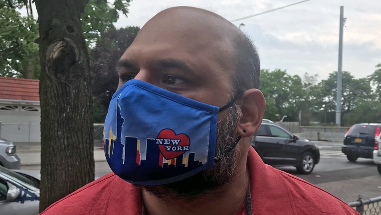 Man wearing a multicolored fabric mask over his face