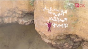 Man in fuchsia business suit climbs into volcano to take a selfie