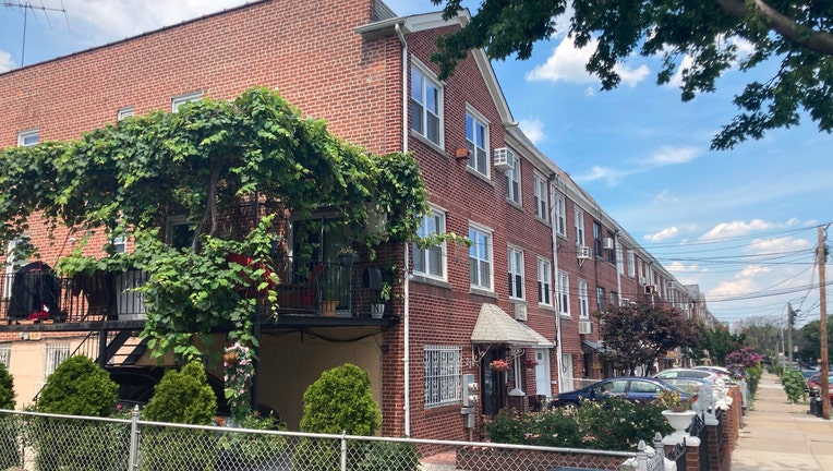 Row of 3-story red brick townhouses on a street