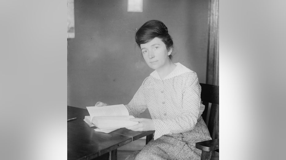 Margaret Sanger seated at a table